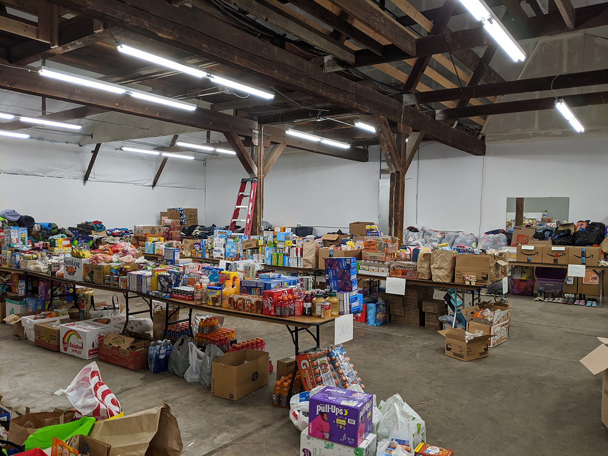 The Good 360 warehouse with rows of tables with stacks of food and goods organized on top