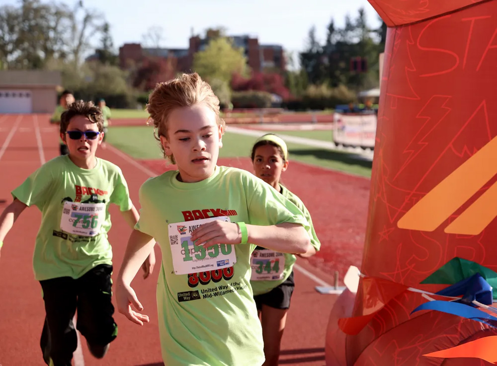 kids wearing green tshirts running in a race
